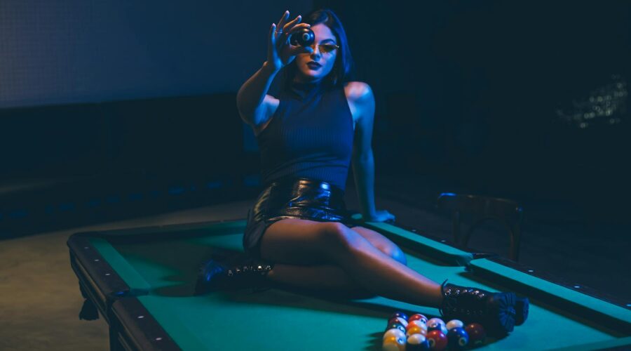 Woman Wearing Black Leather Mini Skirt Sitting on Billiard Table